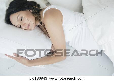 Stock Image - Pregnant Caucasian woman sleeping in bed. Fotosearch