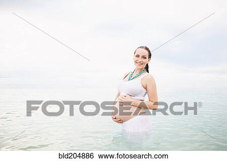 Pregnant Caucasian woman standing in water View Large Photo Image Stock Photograph - Pregnant Caucasian woman standing in water. Fotosearch