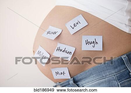 Stock Photo - Pregnant Caucasian woman with name suggestions on belly. Fotosearch