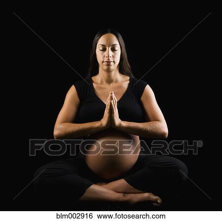 Stock Photograph - Pregnant Middle Eastern woman doing yoga. Fotosearch