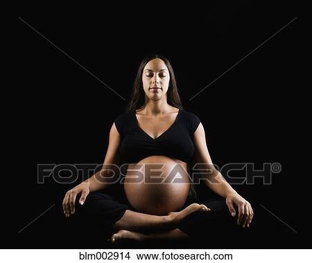 Pregnant Middle Eastern woman sitting cross-legged on floor View Large Photo Image Picture - Pregnant Middle Eastern woman sitting cross-legged on floor. Fotosearch