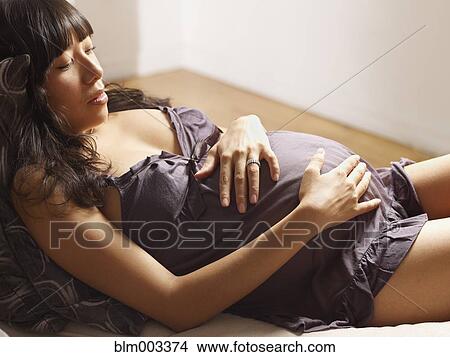 Picture - Pregnant mixed race woman relaxing. Fotosearch