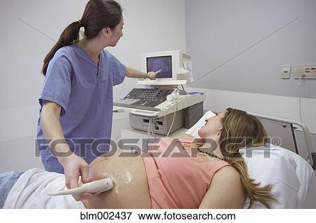 Stock Photo - Pregnant woman having ultrasound procedure. Fotosearch