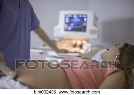 Pregnant woman having ultrasound procedure View Large Photo Image Stock Photography - Pregnant woman having ultrasound procedure. Fotosearch