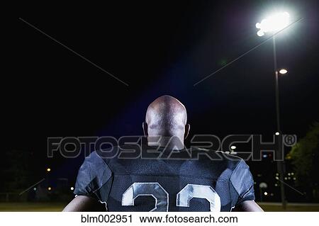 Stock Image - Rear view of African football player in uniform. Fotosearch