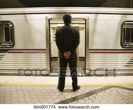 Rear view of businessman on train platform View Large Photo Image Picture - Rear view of businessman on train platform. Fotosearch