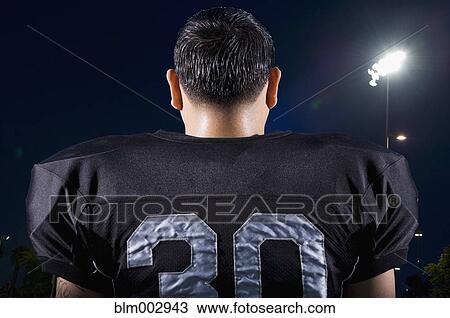 Stock Image - Rear view of Hispanic football player in uniform. Fotosearch