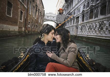 Stock Photo - Romantic Italian couple riding in gondola through canal. Fotosearch