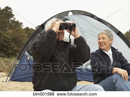 Senior Asian couple camping with binoculars View Large Photo Image Stock Photo - Senior Asian couple camping with binoculars. Fotosearch