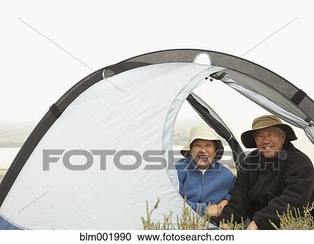 Senior Asian couple sitting in tent smiling View Large Photo Image Stock Image - Senior Asian couple sitting in tent smiling. Fotosearch