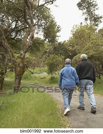 Senior couple holding hands and walking outdoors View Large Photo Image Stock Image - Senior couple holding hands and walking outdoors. Fotosearch