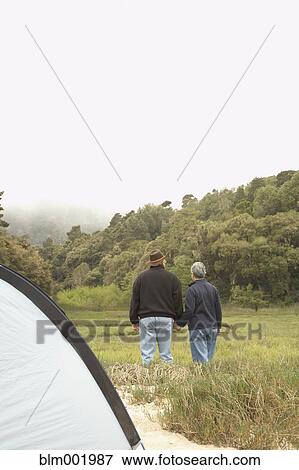 Senior couple holding hands next to tent View Large Photo Image Stock Photo - Senior couple holding hands next to tent. Fotosearch