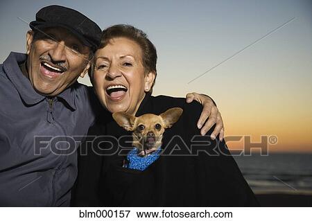 Senior Hispanic couple hugging with dog View Large Photo Image Stock Photo - Senior Hispanic couple hugging with dog. Fotosearch