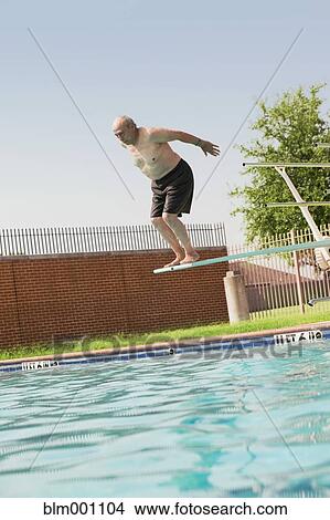 Senior Hispanic man diving off board into swimming pool View Large Photo Image Picture - Senior Hispanic man diving off board into swimming pool. Fotosearch