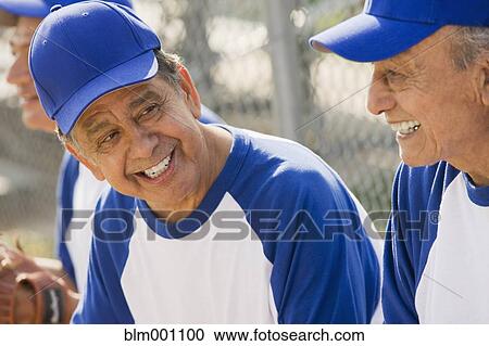 Stock Image - Senior Hispanic men playing on baseball team. Fotosearch