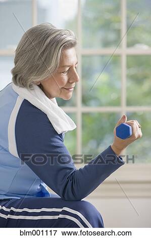 Senior Hispanic woman lifting hand weights View Large Photo Image Stock Photo - Senior Hispanic woman lifting hand weights. Fotosearch
