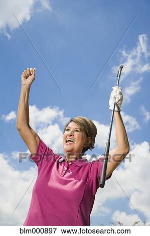 Stock Photo - Senior Hispanic woman playing golf. Fotosearch