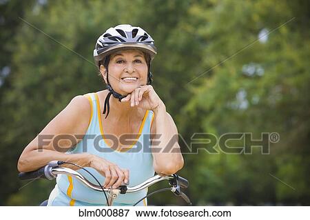 Stock Photo - Senior Hispanic woman riding bicycle. Fotosearch