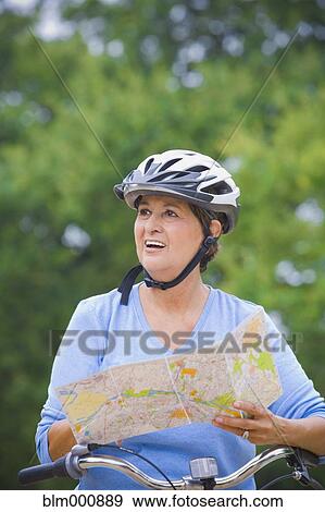 Stock Photo - Senior Hispanic woman riding bicycle. Fotosearch