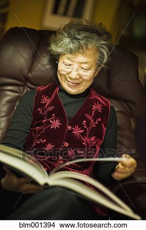 Picture - Senior Japanese woman reading book. Fotosearch