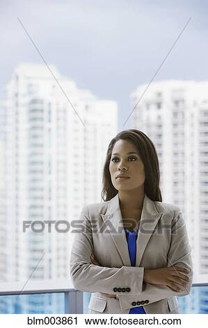 Stock Image - Serious African businesswoman on urban balcony. Fotosearch