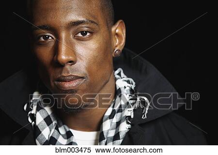 Stock Photography - Serious African man in trench coat. Fotosearch