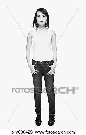 Stock Image - Serious Asian woman in blue jeans. Fotosearch
