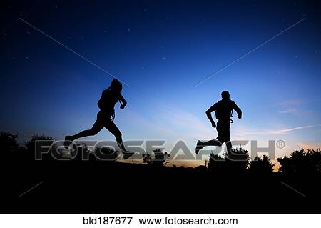 Silhouette of Caucasian couple running at dawn View Large Photo Image Stock Photo - Silhouette of Caucasian couple running at dawn. Fotosearch