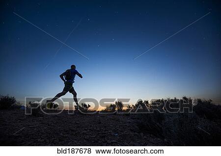 Stock Photo - Silhouette of Caucasian teenage boy running at dawn. Fotosearch