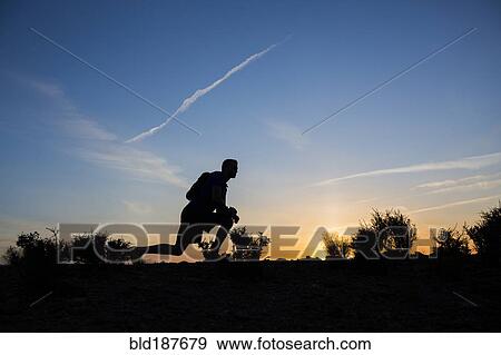 Silhouette of Caucasian teenage boy running at dawn View Large Photo Image Stock Photo - Silhouette of Caucasian teenage boy running at dawn. Fotosearch