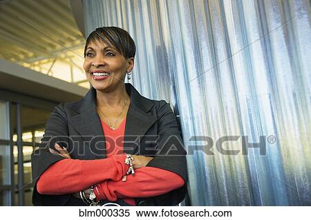 Stock Photography - Smiling African businesswoman with arms crossed. Fotosearch