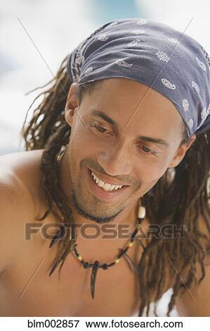 Stock Photo - Smiling, bare chested Hispanic man in headscarf. Fotosearch