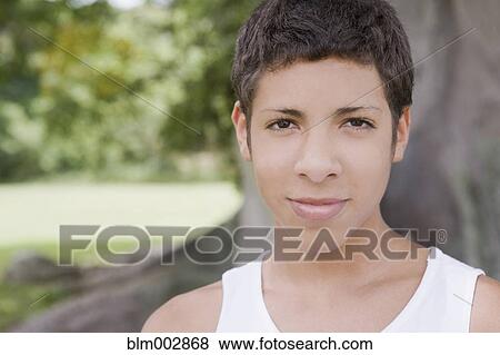 Stock Photo - Smiling Hispanic teenage boy standing outdoors. Fotosearch