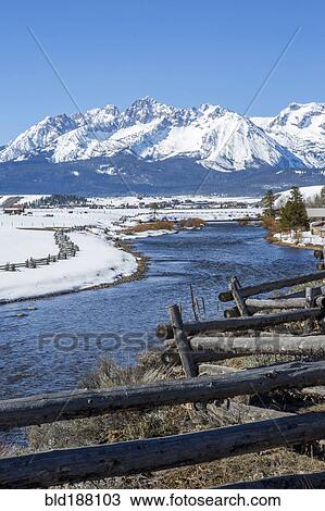 Stock Image - Snowy mountains and river in rural landscape. Fotosearch