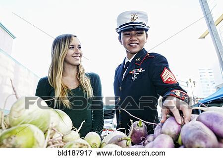 Stock Photo - Soldier and friend shopping in farmers market. Fotosearch