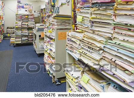 Stock Photograph - Stacks of papers and folders in library. Fotosearch