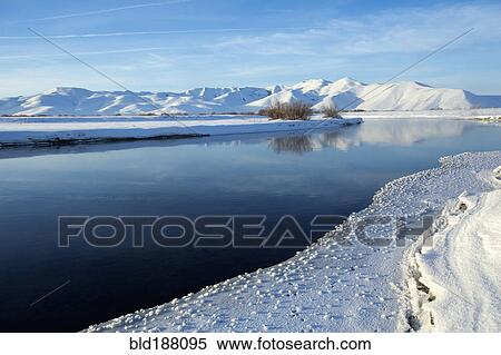 Stock Photography - Still river in snowy remote landscape. Fotosearch