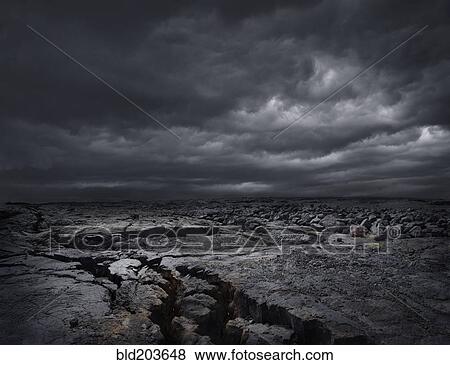 Stock Photo - Storm clouds over dry rocky landscape. Fotosearch