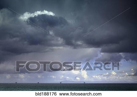Stormy sky over oil drilling platforms in ocean View Large Photo Image Stock Photograph - Stormy sky over oil drilling platforms in ocean. Fotosearch