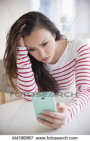 Stock Photo - Stressed woman using cell phone. Fotosearch