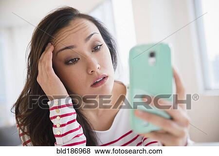 Stock Photo - Stressed woman using cell phone. Fotosearch