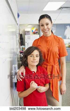 Stock Photo - Student and teacher smiling in classroom. Fotosearch