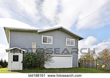 Stock Image - Suburban house under cloudy sky. Fotosearch