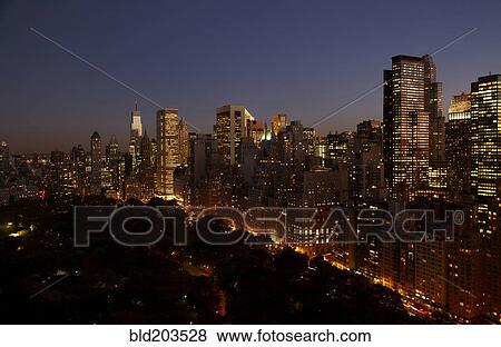 Stock Photo - Sunset and illuminated cityscape, New York, New York, United States. Fotosearch