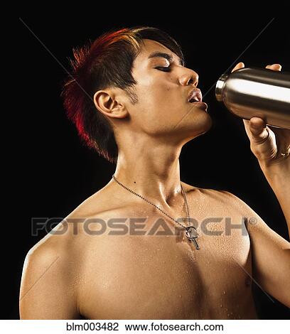 Stock Image - Sweating Asian man drinking water. Fotosearch