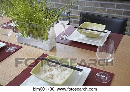 Stock Image - Table set with rice bowls and chopsticks. Fotosearch
