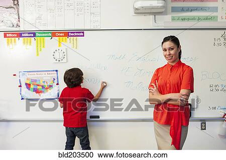 Stock Image - Teacher and student in classroom. Fotosearch