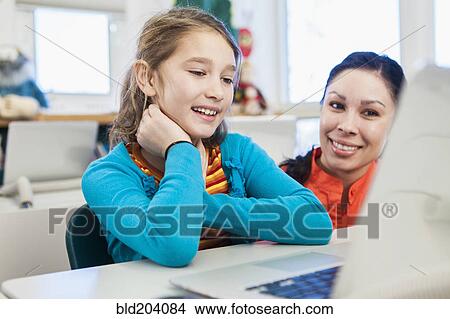 Teacher and student using laptop in library View Large Photo Image Picture - Teacher and student using laptop in library. Fotosearch
