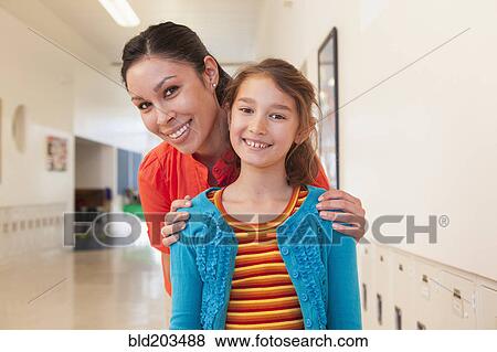 Teacher hugging student in school hallway View Large Photo Image Stock Photo - Teacher hugging student in school hallway. Fotosearch