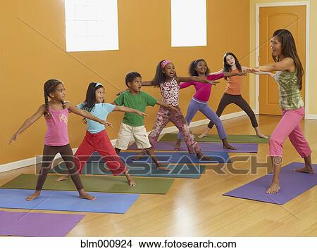 Teacher leading class of children in exercise routine View Large Photo Image Picture - Teacher leading class of children in exercise routine. Fotosearch